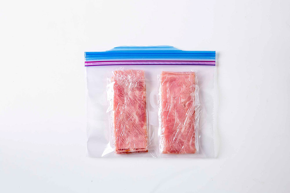 ベーコンは半分に切って1枚ずつラップに並べてじゃばらに包み、冷凍用保存袋に入れて冷凍。